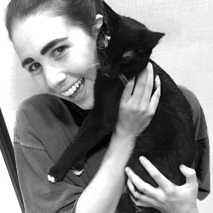 smiling woman holding a black cat