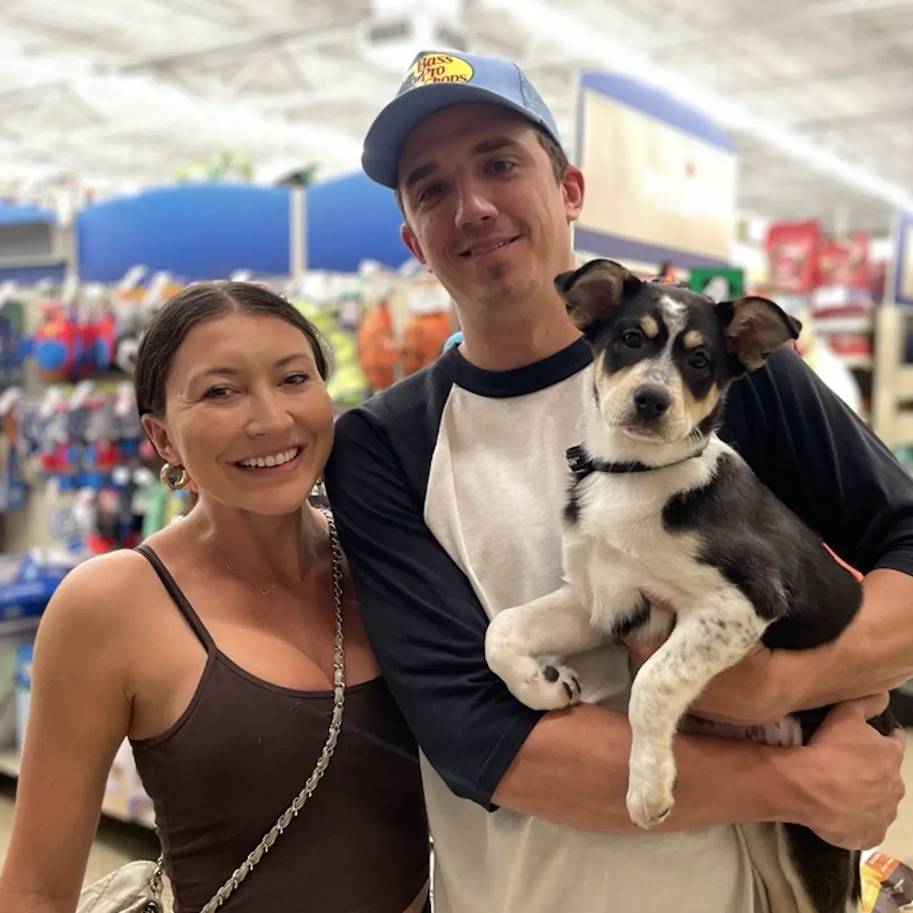 Couple stand in PetSmart store holding their newly adopted dog