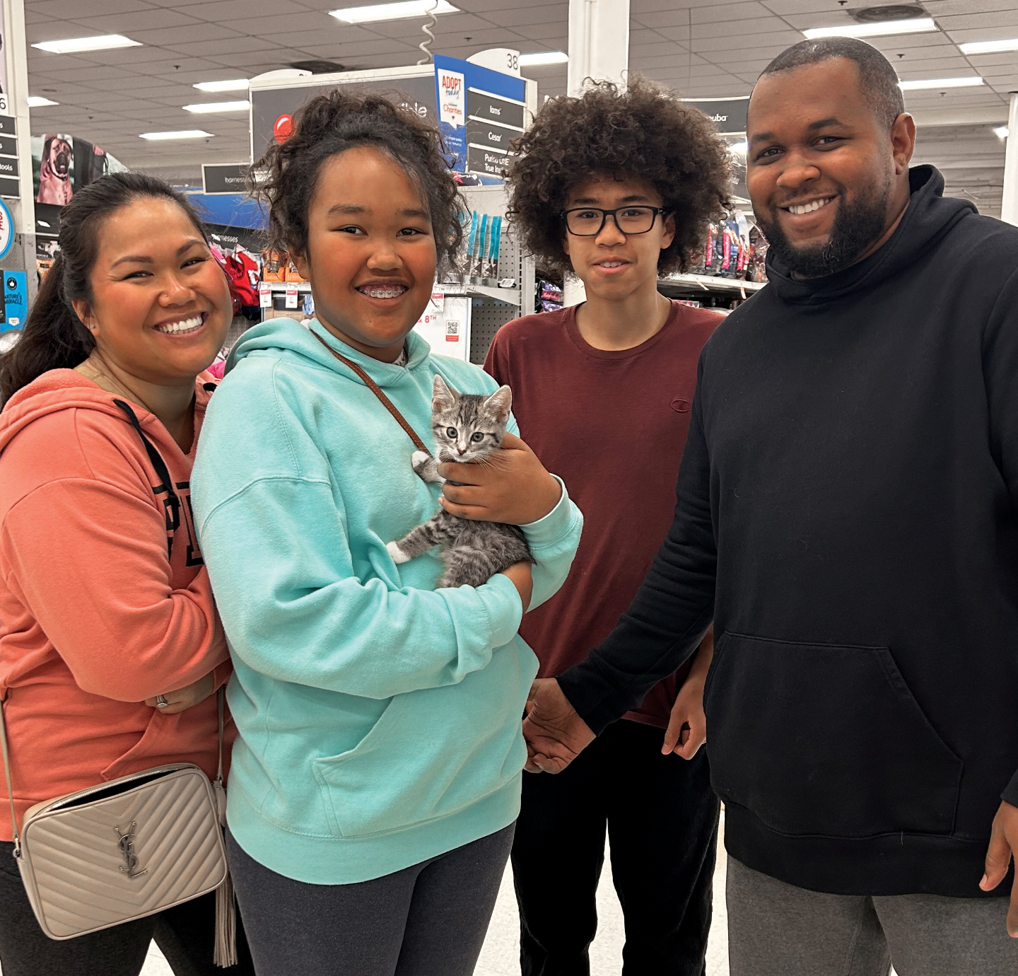 Family of four pose with their new adopted kitten