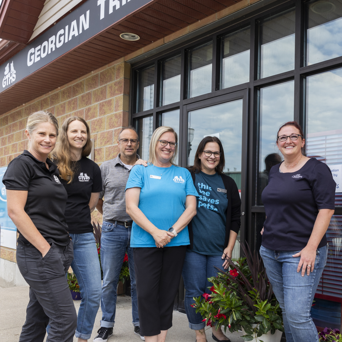 a group of animal welfare professionals pose for a photo out front of a Georgian Triangle Humane Society building