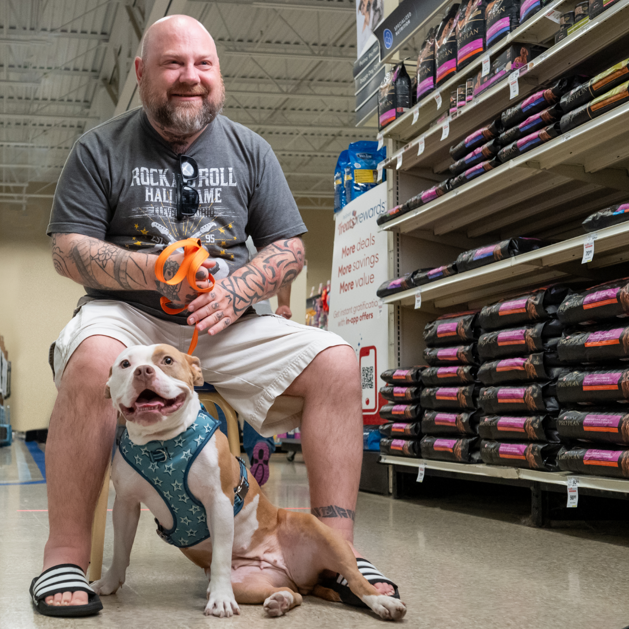 a man sits with his newly adopted dog in an aisle of a PetSmart